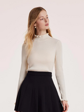 a lady in a cream ruffle turtleneck sweater